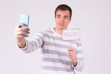 Portrait of happy man taking selfie with paper sign