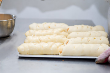 raw bread rolls on a baking tray