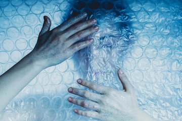 Blaues Licht umhüllt von einer Frau Hinter Plastik Bubble Folie