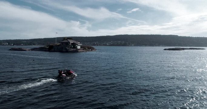 jetski having lots of fun in the fjords of Norway, located in Langesund- Dude totally chilled on the jetski, from above, drone footage.