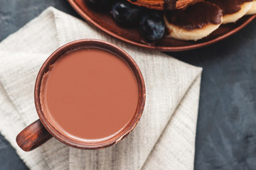 Cup of sweet hot chocolate drink on dark background, top view