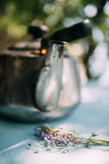 Camping kettle with a mug on the table outdoors