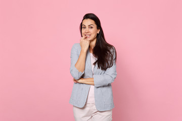 Portrait of smiling impatient young woman in striped jacket standing, gnawing nails isolated on...