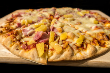 Close up view of a ham and pineapple Hawaiian pizza