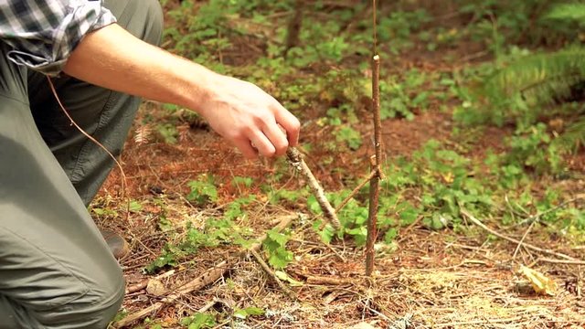 Man demonstrates a snare trigger during wilderness survival class