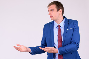 Portrait of businessman in suit thinking and showing something