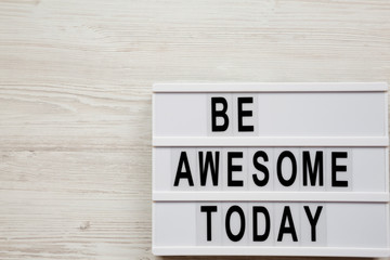 'Be awesome today' word on modern board over white wooden surface, from above. Overhead, top view. Copy space.