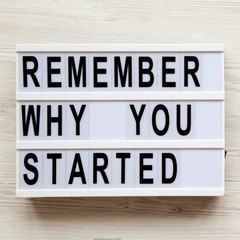 'Remember why you started' words on lightbox over white wooden surface, view from above. Top view, flat lay, overhead.