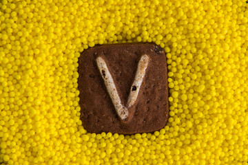 letters of the English alphabet on the background of yellow sweet balls