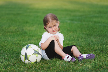 little happy girl on football field