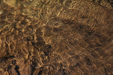 Ripples in water with golden rays shining through