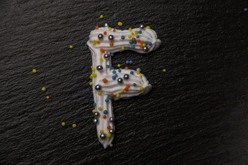 Letters written with whipped cream and decorated with colored balls
