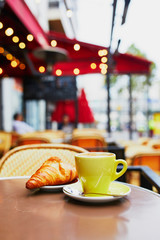 Cup of fresh hot coffee and traditional French croissant