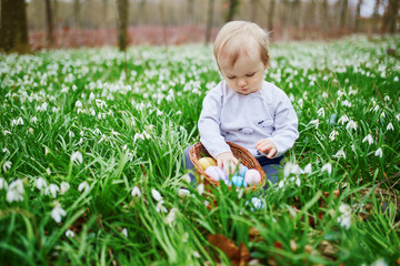 Cute little one year old girl playing egg hunt on Easter