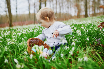 Cute little one year old girl playing egg hunt on Easter