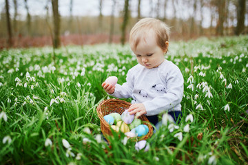 Cute little one year old girl playing egg hunt on Easter