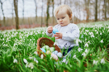 Cute little one year old girl playing egg hunt on Easter