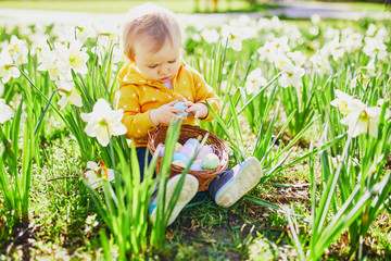 Cute little one year old girl playing egg hunt on Easter