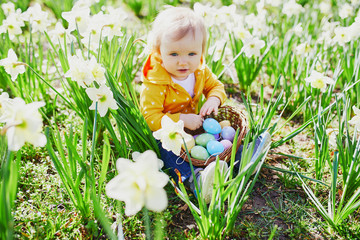 Cute little one year old girl playing egg hunt on Easter