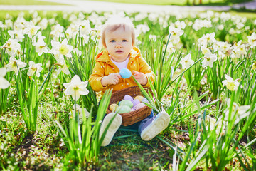 Cute little one year old girl playing egg hunt on Easter
