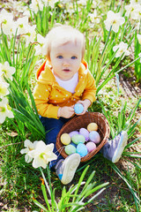 Cute little one year old girl playing egg hunt on Easter