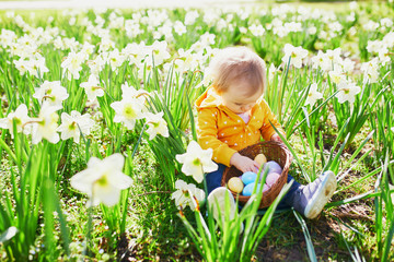 Cute little one year old girl playing egg hunt on Easter