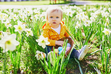 Cute little one year old girl playing egg hunt on Easter