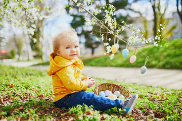 Cute little one year old girl playing egg hunt on Easter