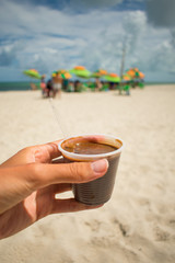 Hand holding a plastic cup of 