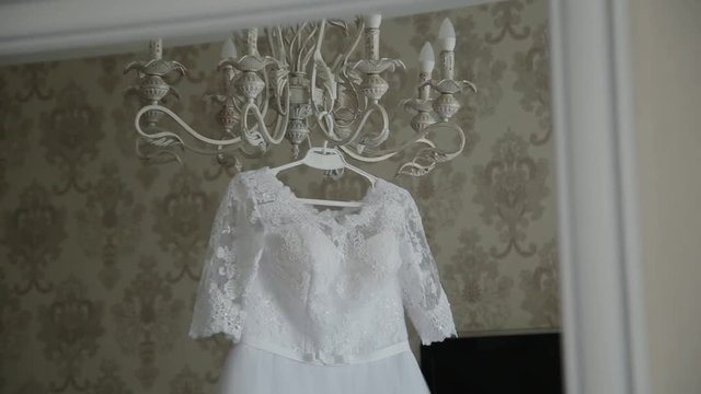 Beautiful wedding dress hanging in a large chandelier.