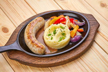 sausage with mashed potato and vegetables, wooden background