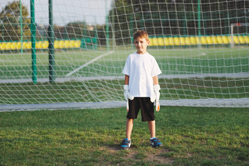 little happy boy on football field