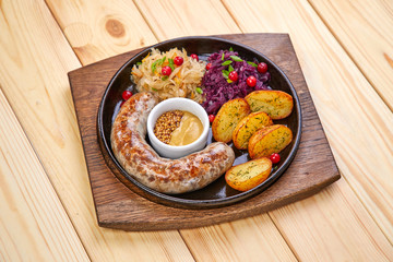 sausage with baked potatoes and salad on the wooden background