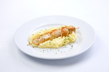 chicken kebab with mashed potato on the white plate