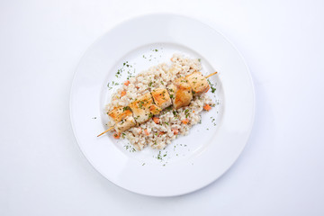 chicken kebab with barley on the white plate