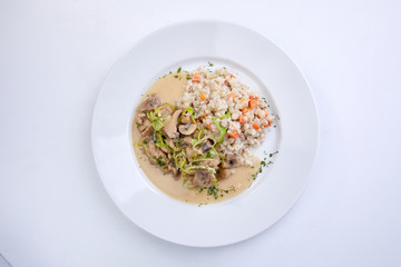 meat with vegetables and barley on the white background