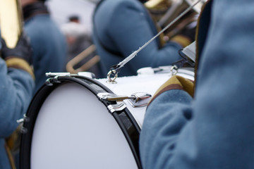 Closeup detail of retro weared standing back soldier drummer with big drum and other soldiers...