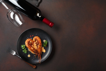 Romantic dinner with heart-shaped shrimps and wine on a brown background. Top view with copy space