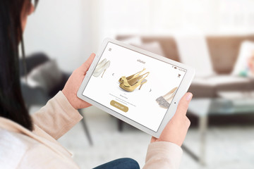 Woman shopping online with tablet. Modern commerce web site interface with shoes.
