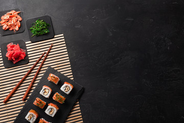 Set of sushi and maki with a bottle of wine on stone table. Top view with copy space