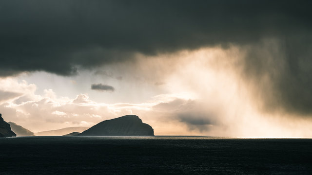 Rain clouds in the distance followed by sunlight  in the Faroe Islands