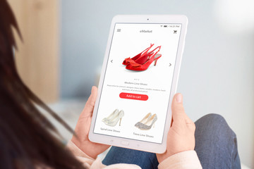 Close-up tablet with eccommerce web site in woman hands. Shoes store concept. Flat design interface.