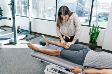 Physical therapist presses on a  man's knee