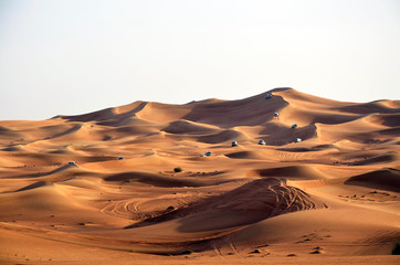 Fototapeta na wymiar Desert safari on sand dunes on the off-road cars