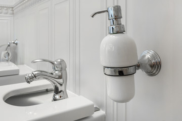 toilet and detail of a corner shower bidet with soap and shampoo dispensers on wall mount shower attachment