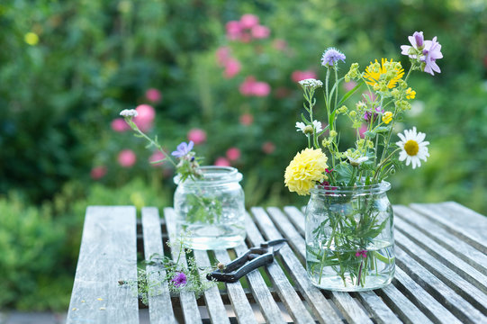 Wildflowers in preserving jars on garden table