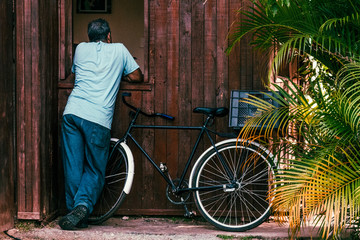 man and bicycle in front of old house