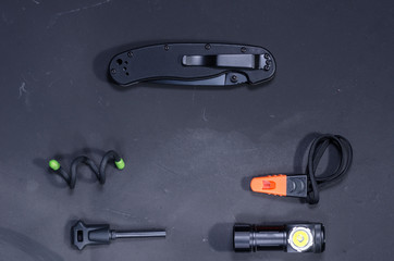 Black items on a black background. Black knife with a clip.