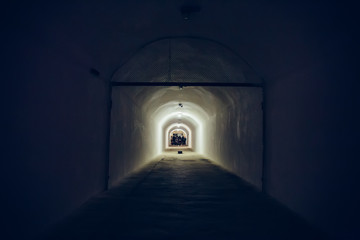 Fototapeta premium Long corridor or illuminated tunnel in bomb shelter, underground military bunker of cold war, perspective