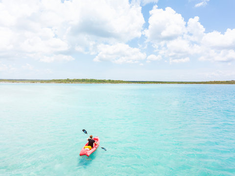 Mexico, Yucatan, Quintana Roo, Bacalar, woman in kayak on the sea in turquoise water, drone image